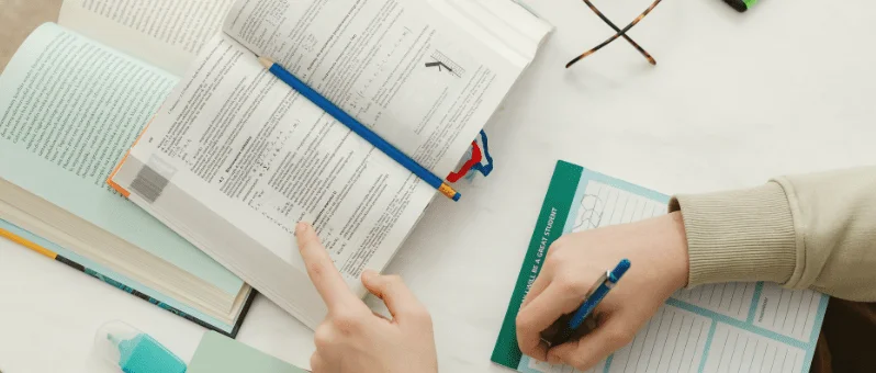 Sách luyện thi IELTS và ghi chép trên bàn học